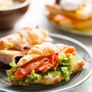 a plate with a sandwich with lettuce and tomatoes at Astoria Hotel in Vladivostok