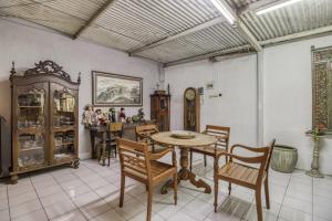 uma sala de jantar com mesa e cadeiras em RedDoorz Hostel near Adisucipto Airport Yogyakarta em Yogyakarta