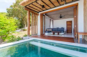 an outdoor living area with a swimming pool and a house at The Humble Villas in Ban Bang Po