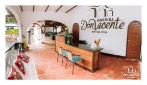 a restaurant with a counter and chairs in a room at Hacienda Don Vicente Bungalows-Tarapoto in Tarapoto