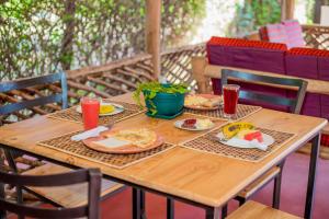 a wooden table with plates of food on it at The Better Inn in Moshi