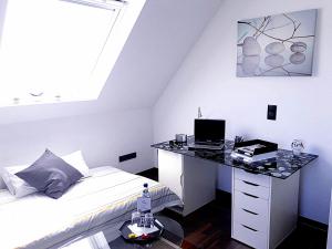 a white bedroom with a desk and a bed at GÄSTEHAUS LIFESTYLE in Kirrweiler