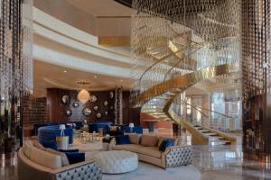a lobby with a spiral staircase and blue furniture at Paramount Hotel Dubai in Dubai