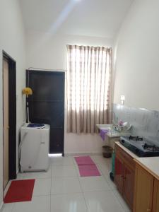 a small kitchen with a sink and a refrigerator at Hazz Homestay Alor Setar in Alor Setar
