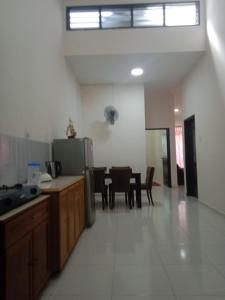 a kitchen and dining room with a table and a refrigerator at Hazz Homestay Alor Setar in Alor Setar