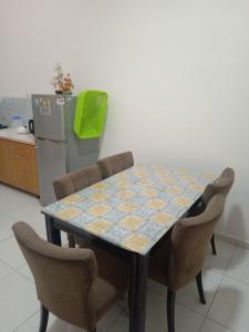 a dining room table with chairs and a refrigerator at Hazz Homestay Alor Setar in Alor Setar