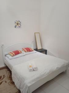 Hazz Homestay Alor Setar في ألور سيتار: غرفة نوم مع سرير أبيض كبير مع وسائد حمراء