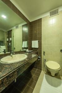 a bathroom with a sink and a toilet at The Pearl in Hassan