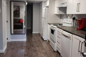 a kitchen with white appliances and a wooden floor at 1-Bedroom Mi Casita by Amazing Property Rentals in Gatineau