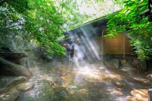 南小國的住宿－inn NOSHIYU，一条小溪旁的瀑布,有一座建筑