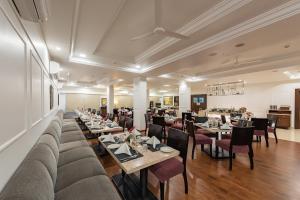 a restaurant with couches and tables and chairs at The Pearl in Hassan