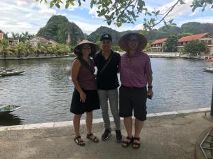 a group of three people standing next to a river at Hanoi Golden Hostel in Hanoi
