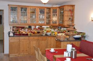 una cocina con armarios de madera, mesa y sillas en Haus Binter, en Weissensee