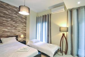um quarto com 2 camas e uma parede de tijolos em Studio 20 (the best spot in town !) em Patra