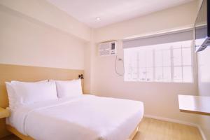 una camera con un letto bianco e una finestra di Bridge Hotel Express a Cagayan de Oro