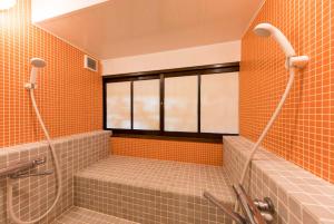 a bathroom with orange tiled walls and a shower at Guest House Maru in Kashima +40 photos