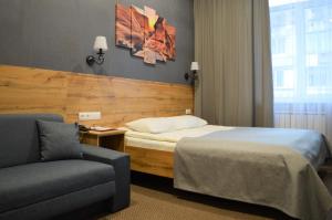 ヨシュカル・オラにあるVirginia Hotelのベッドとソファ付きのホテルルーム