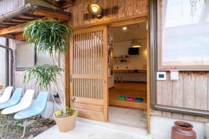um quarto com uma porta de madeira e algumas cadeiras em Guest House Maru em Kashima