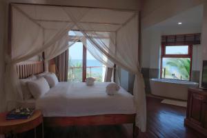 a bedroom with a bed with two stuffed animals on it at Cardamon Hotel Nilaveli in Nilaveli