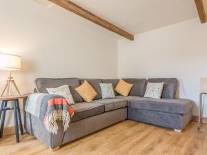 a living room with a gray couch with pillows at Potters by the Sea in Penzance