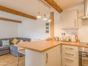 a kitchen with a counter top and a couch at Potters by the Sea in Penzance