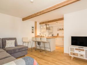 a living room with a couch and a kitchen at Potters by the Sea in Penzance +10 photos
