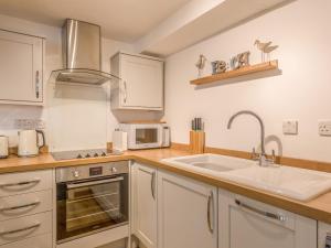 a kitchen with a sink and a microwave at Potters by the Sea in Penzance