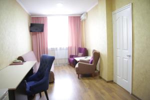 a hotel room with chairs and a table and a window at City Hotel in Ustʼ-Kamenogorsk