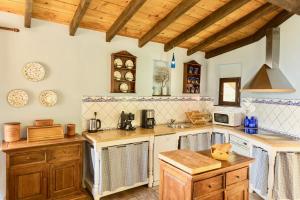 a large kitchen with wooden cabinets and a wooden ceiling at Villa Manavra in Ipsos