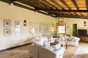 a living room with white couches and a tv at Villa Manavra in Ipsos
