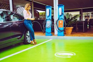 a woman standing next to a car at a gas station at Hotel Albaida Nature in Mazagón