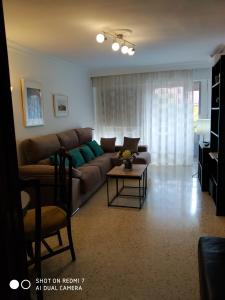 sala de estar con sofá y mesa en Luminoso y amplio apartamento en Sevilla