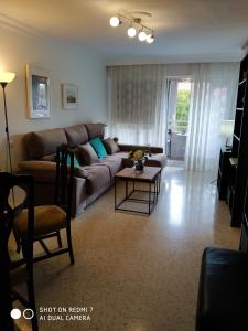 sala de estar con sofá y mesa en Luminoso y amplio apartamento, en Sevilla