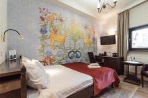 a hotel room with a bed and a wall mural at Hotel Ester in Kraków
