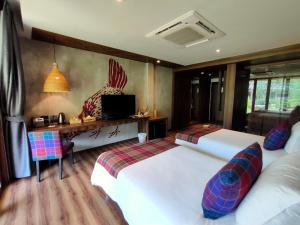 1 dormitorio con 2 camas y escritorio con ordenador en Recall Isaan Isan Concept at Khaoyai SHA Extra Plus, en Mu Si