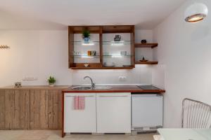 a kitchen with white cabinets and a sink at Studio Sergio in Bled