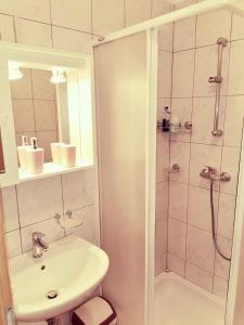 a white bathroom with a shower and a sink at Studio Sonja in Piran