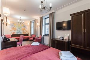 a hotel room with a pink bed and a dining room at Hotel Ester in Kraków