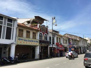 a city street with buildings and cars on the road at Thian Siong Inn in Malacca