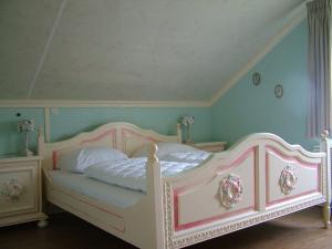 Una cama rosa y blanca en una habitación con paredes azules. en B&B Elbahof, goed en goedkoop!, en Hem