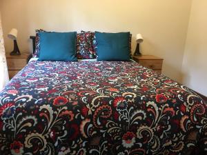 a bed with a black and red blanket and blue pillows at Farm guests house in Somersby