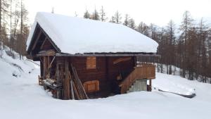 a log cabin with snow on top of it at Ferienhütte Ortnerkasa in Heiligenblut