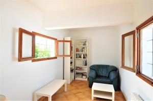 a living room with a chair and a book shelf at XOROI- Villa primera linea mar con vistas a Bahía Alcudia in Artá