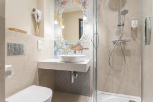 a bathroom with a sink and a shower at Hotel Ester in Kraków