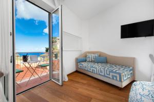 ソレントにあるLuxury Home Sea View & Jacuzzi in Sorrento centreのベッドルーム1室(ベッド1台付)、海を望むバルコニーが備わります。