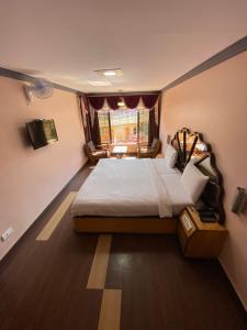 a bedroom with a large bed and a window at HOTEL VENUS in Ooty