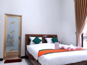 a bedroom with a bed and a window at Homestay Purbalingga Tengah Kota by Simply Homy in Purbolinggo