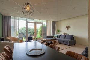 - un salon avec une table et un canapé dans l'établissement Strandslag 115 Beach Apartment, à Julianadorp
