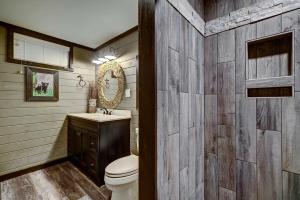 uma casa de banho com um WC, um lavatório e um espelho. em Rebel Retreat cabin em Pigeon Forge