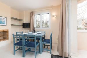 comedor con mesa azul y sillas en ORO DEL MAR IV Apartamento O2, en Canyamel